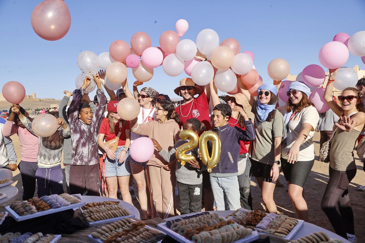 Enfants et équipages célébrant la remise de dons avec des ballons